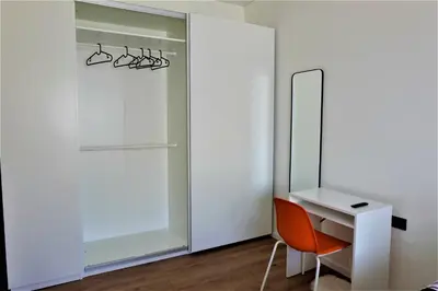 a white desk with a chair next to a mirror at Nauji apartamentai su kiemeliu in Kaunas