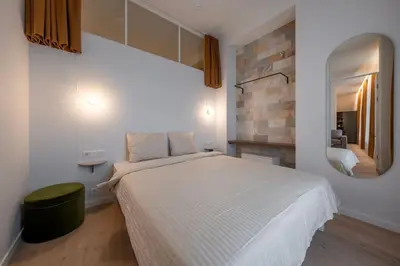 a bedroom with a large bed and a mirror at Downtown getaway apartments by Prime Rentals I in Kaunas