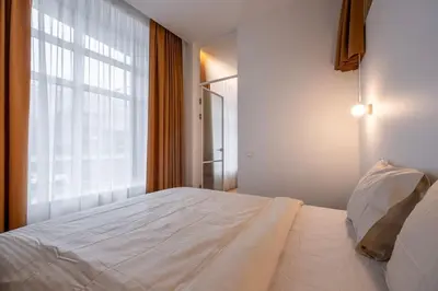 a white bed in a room with a window at Downtown getaway apartments by Prime Rentals I in Kaunas