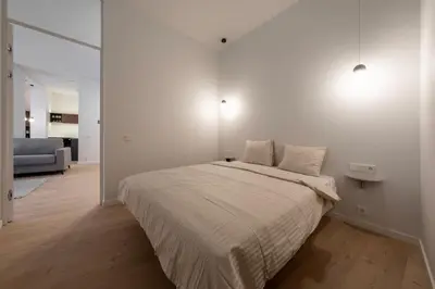 a white bedroom with a bed and a couch at Downtown getaway apartments by Prime Rentals I in Kaunas