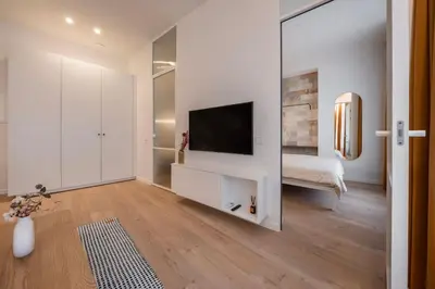 a white room with a television and a bed at Downtown getaway apartments by Prime Rentals I in Kaunas