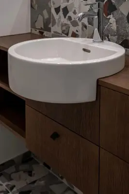 a white sink on a wooden cabinet in a bathroom at Downtown getaway apartments by Prime Rentals IV in Kaunas