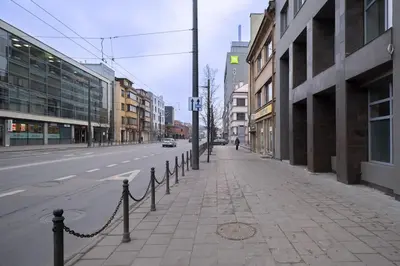 an empty city street with buildings and a chain fence at Downtown getaway apartments by Prime Rentals IV in Kaunas