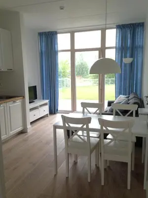 a kitchen and living room with a table and chairs at Domi Lini in Druskininkai