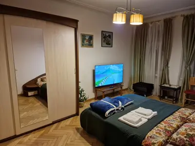 a bedroom with a bed and a television with towels at Kaunas Center Apartment in Kaunas