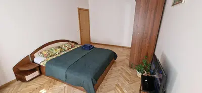 a bedroom with a bed with a green blanket at Kaunas Center Apartment in Kaunas