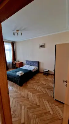 a bedroom with a bed and a wooden floor at Kaunas Center Apartment in Kaunas