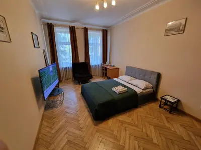 a living room with a bed and a flat screen tv at Kaunas Center Apartment in Kaunas