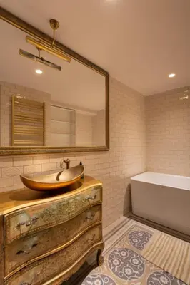 a bathroom with a sink and a mirror and a tub at Uzupis Angel 3 bedroom Apartment in Vilnius