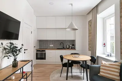 a kitchen and living room with a table and chairs at New and modern apartment in Old Town by URBAN RENT in Vilnius