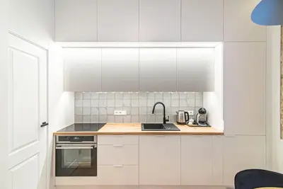 a kitchen with white cabinets and a sink at New and modern apartment in Old Town by URBAN RENT in Vilnius