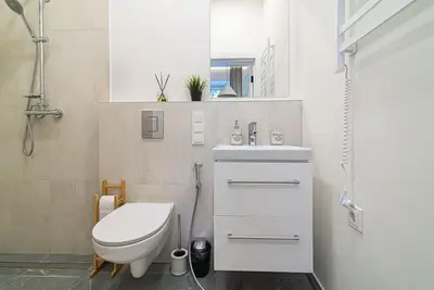 a white bathroom with a toilet and a sink at New and modern apartment in Old Town by URBAN RENT in Vilnius