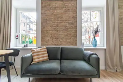 a living room with a couch and a brick wall at New and modern apartment in Old Town by URBAN RENT in Vilnius