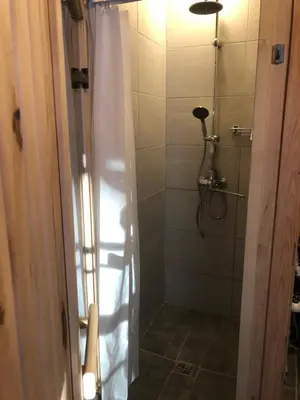 a bathroom with a shower with a shower curtain at Liepų pirtis in Smailiai