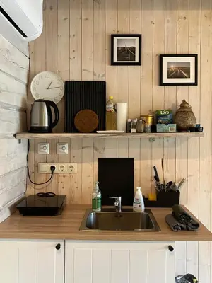 a kitchen with a sink and a clock on the wall at Liepų pirtis in Smailiai