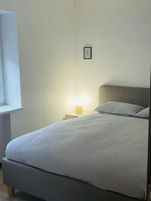 a bedroom with a bed and a lamp on a table at S&T&A&R apartamentai in Panevėžys