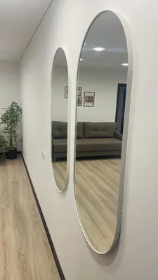 a mirror on a wall in a room with a couch at S&T&A&R apartamentai in Panevėžys