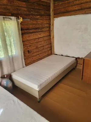 a mattress bed in a room with a window at Šimtametis namelis in Anykščiai