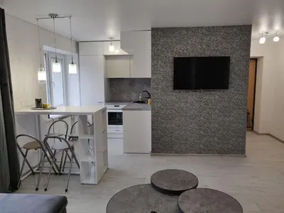 a kitchen and living room with a tv on a wall at Central cozy apartment in Kėdainiai
