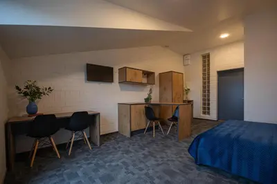 a room with a bed and a table and chairs at LOFT INN Vilnius in Vilnius