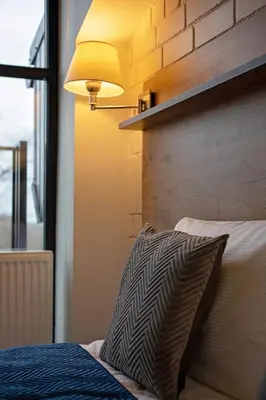 a bedroom with a bed with a pillow and a lamp at LOFT INN Vilnius in Vilnius