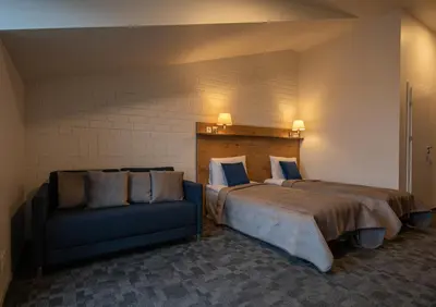 a bedroom with a large bed and a couch at LOFT INN Vilnius in Vilnius