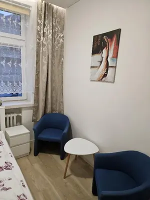 a room with a bed and a chair and a table at Kauno Apartamentai su balkonu in Kaunas