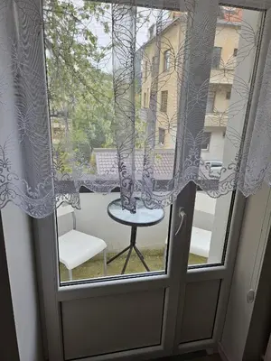 a window with a table and a chair on a balcony at Kauno Apartamentai su balkonu in Kaunas