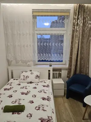 a small bedroom with a bed and a window at Kauno Apartamentai su balkonu in Kaunas