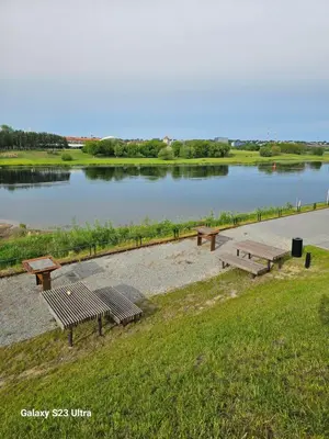 a group of benches sitting next to a lake at Nemunaiciai in Kaunas
