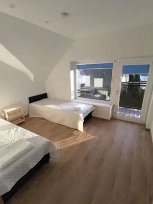 a bedroom with two beds and a large window at Radikiai House in Smiltynai