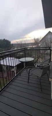 a wooden deck with a table and chairs on a balcony at Radikiai House in Smiltynai