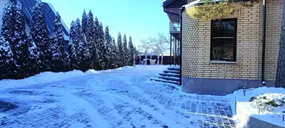 a snow covered street in front of a building at Radikiai House in Smiltynai