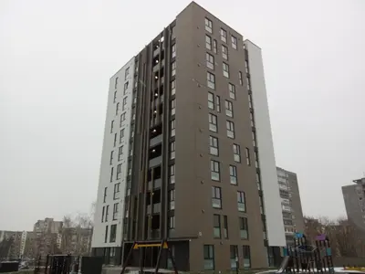 a tall building in the middle of a city at Apartments with a balcony and an impressive terrace on the roof of the house in Vilnius