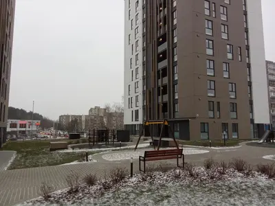 an empty playground in front of a tall building at Apartments with a balcony and an impressive terrace on the roof of the house in Vilnius