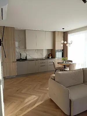 a living room with a couch and a kitchen at Apartments with a balcony and an impressive terrace on the roof of the house in Vilnius