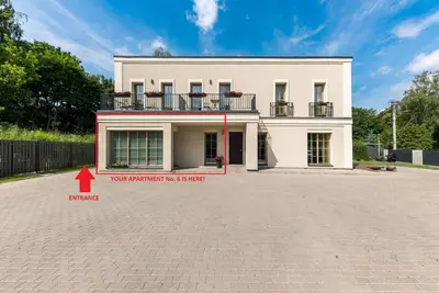 a white house with a red arrow in front of it at Vilnius legends house APARTMENT I Best for families I Free parking in Vilnius