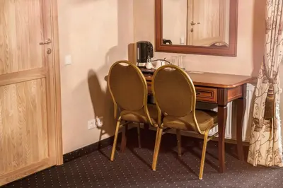 a desk with two chairs next to a wooden table at Patalpų nuoma Žasliuose in Žasliai