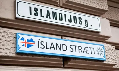 two street signs on the side of a building at Islandijos Self Check-In Basement Apartments in Vilnius