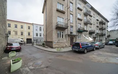 a parking lot with cars parked in front of a building at Islandijos Self Check-In Basement Apartments in Vilnius