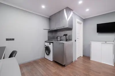 a kitchen with a washing machine and a tv at Islandijos Self Check-In Basement Apartments in Vilnius