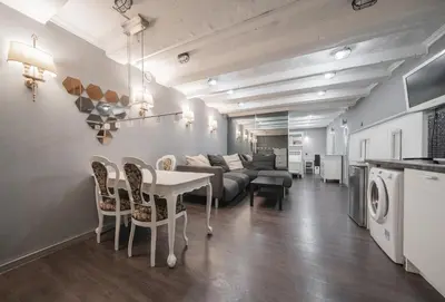 a living room with a couch and a table and chairs at Islandijos Self Check-In Basement Apartments in Vilnius