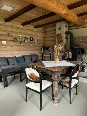 a dining room with a table and chairs and a couch at Kaimo sodyba Dešimt Beržų in Gudžioniai