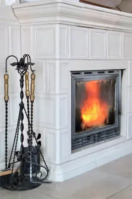 a tripod in front of a fireplace at Kaimo sodyba Dešimt Beržų in Gudžioniai