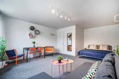 a living room with a bed and a table and chairs at Funky Penthouse City Center in Kaunas