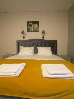 a bedroom with a large bed with two towels on it at Apartamentai Ornamentai in Druskininkai