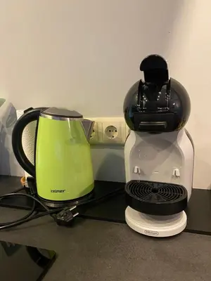a green and white coffee maker sitting on a counter at Apartamentai Ornamentai in Druskininkai