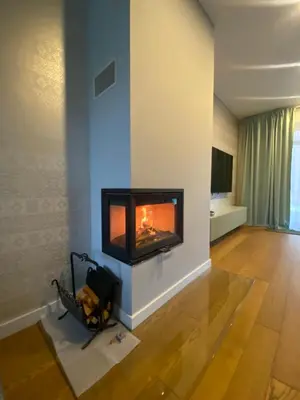 a living room with a fireplace in the wall at Apartamentai Ornamentai in Druskininkai