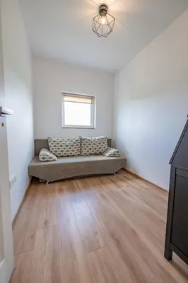 a living room with a couch in the corner of a room at Poilsio oazė in Vynupė