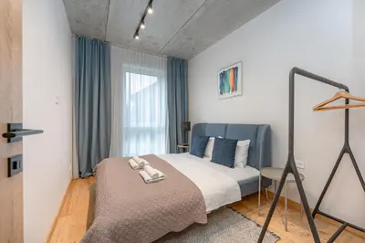 a bedroom with a bed and a window at Brand New White Lotus Apartment 3 by Reside Baltic in Vilnius